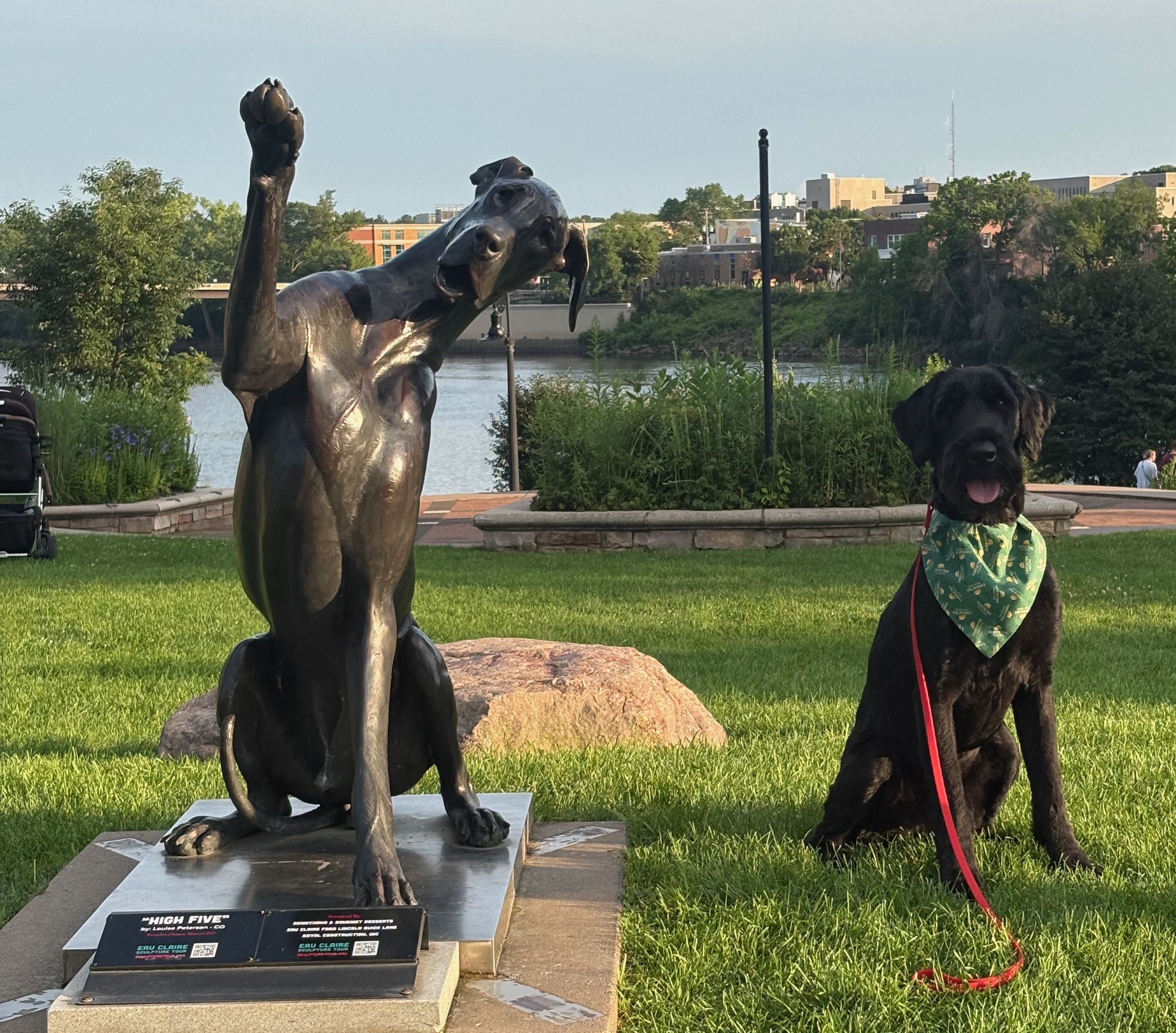 Blu sitting beside a dog statue at Phoenix Park